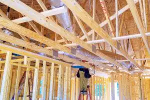 During construction, silver insulation ventilation HVAC pipes were installed from ceiling to roof