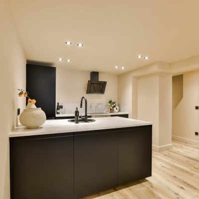 a modern kitchen with black cabinets and white counter tops in the center of the room is an open space for cooking